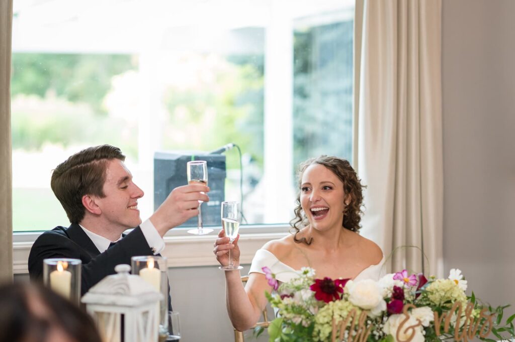 bride and groom toast with champagne glasses during their wedding at the hounds stonington ct