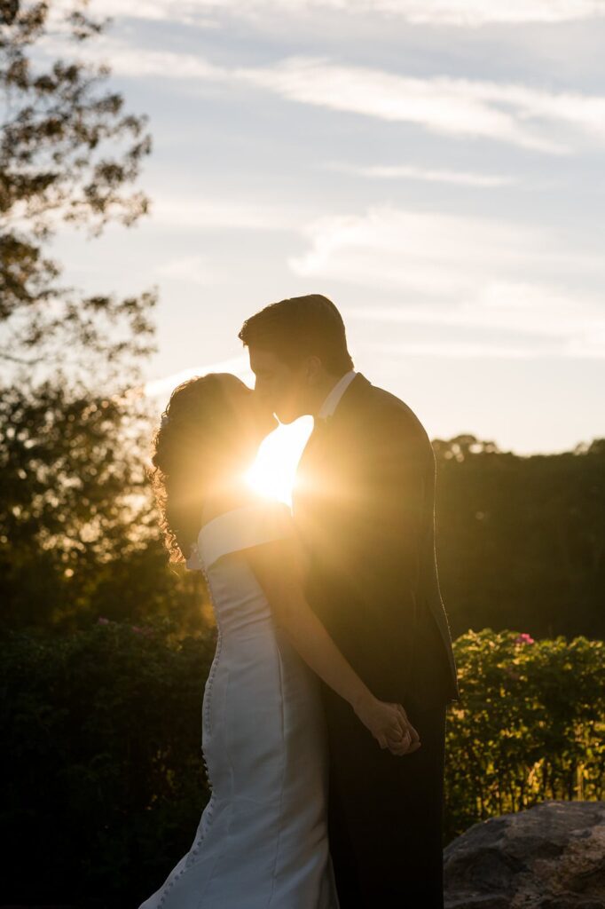 bride and groom silhouetted against the sky and sunset at the hounds in stonington ct