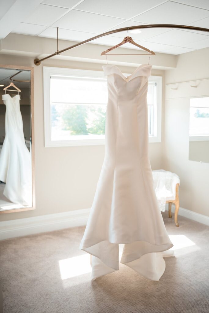 Bridal dress hangs in a window at the hounds stonington ct
