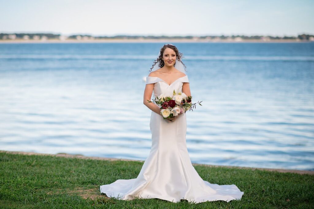 bride holds bouquet and smiles at the stonington lighthouse museum 