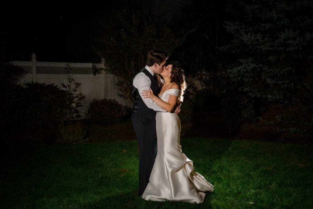 bride and groom embrace in a night photo at their stonington ct wedding, captured by Teresa Johnson Photography
