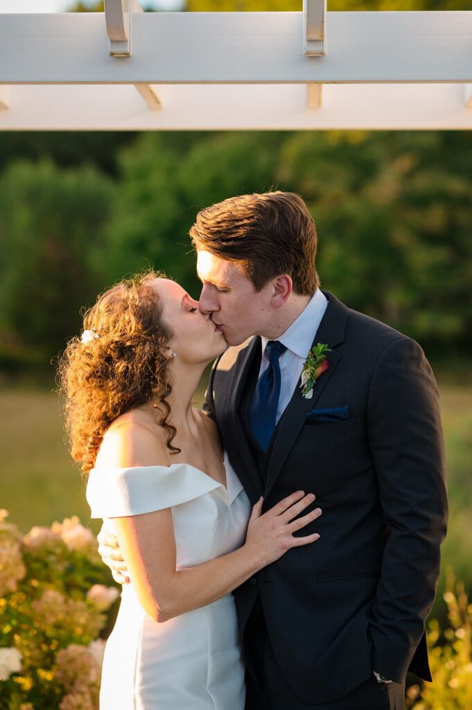 bride and groom kiss in the sunshine at their wedding in stonington ct