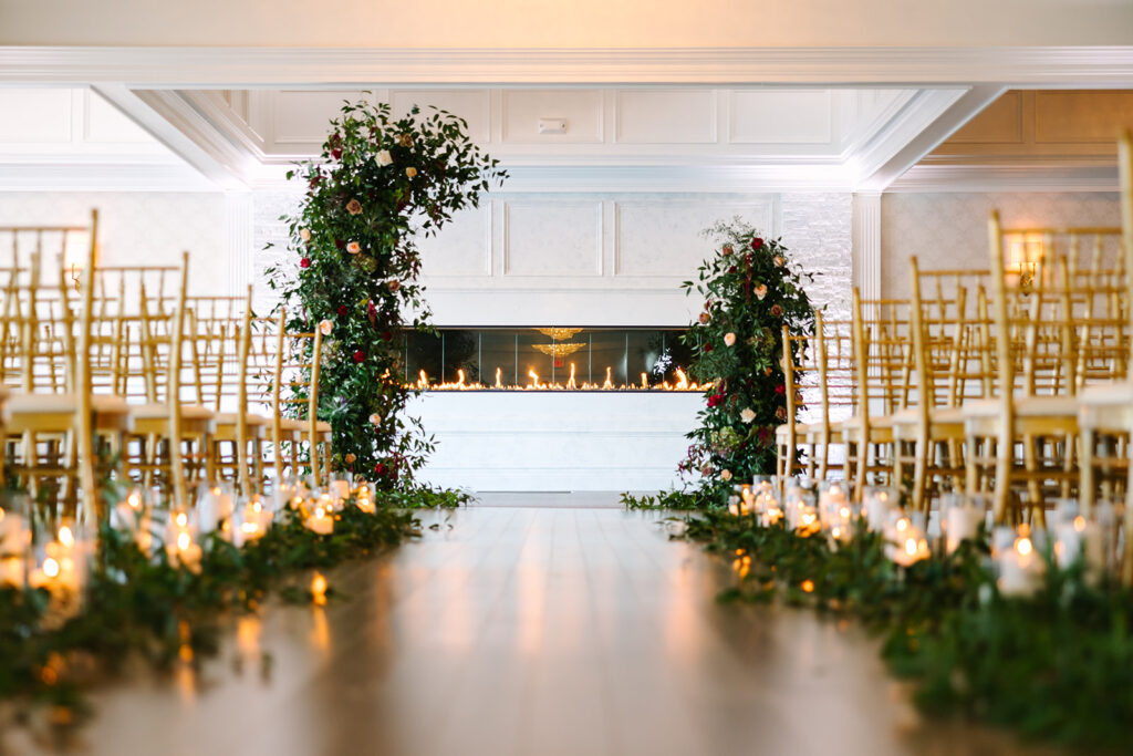 A wedding aisle with chairs and candles.