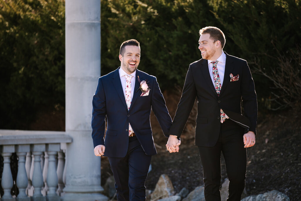 Two men in suits holding hands.