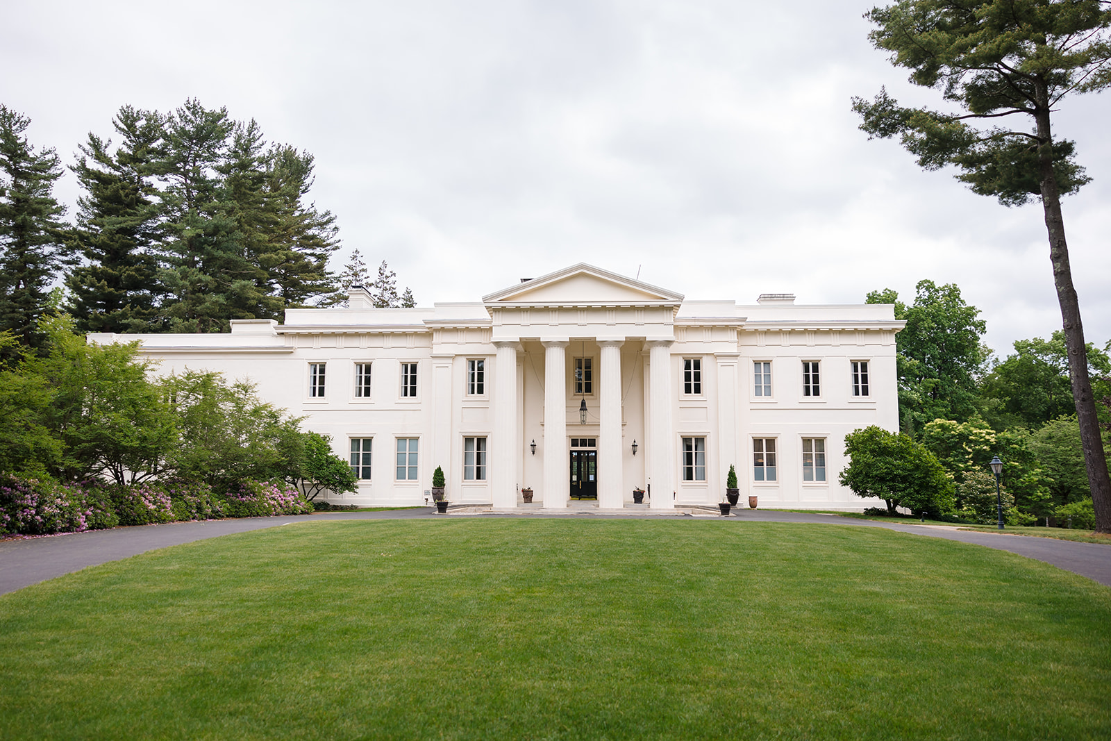 Grand exterior view of Wadsworth Mansion with its stately columns, surrounded by lush greenery and a manicured lawn